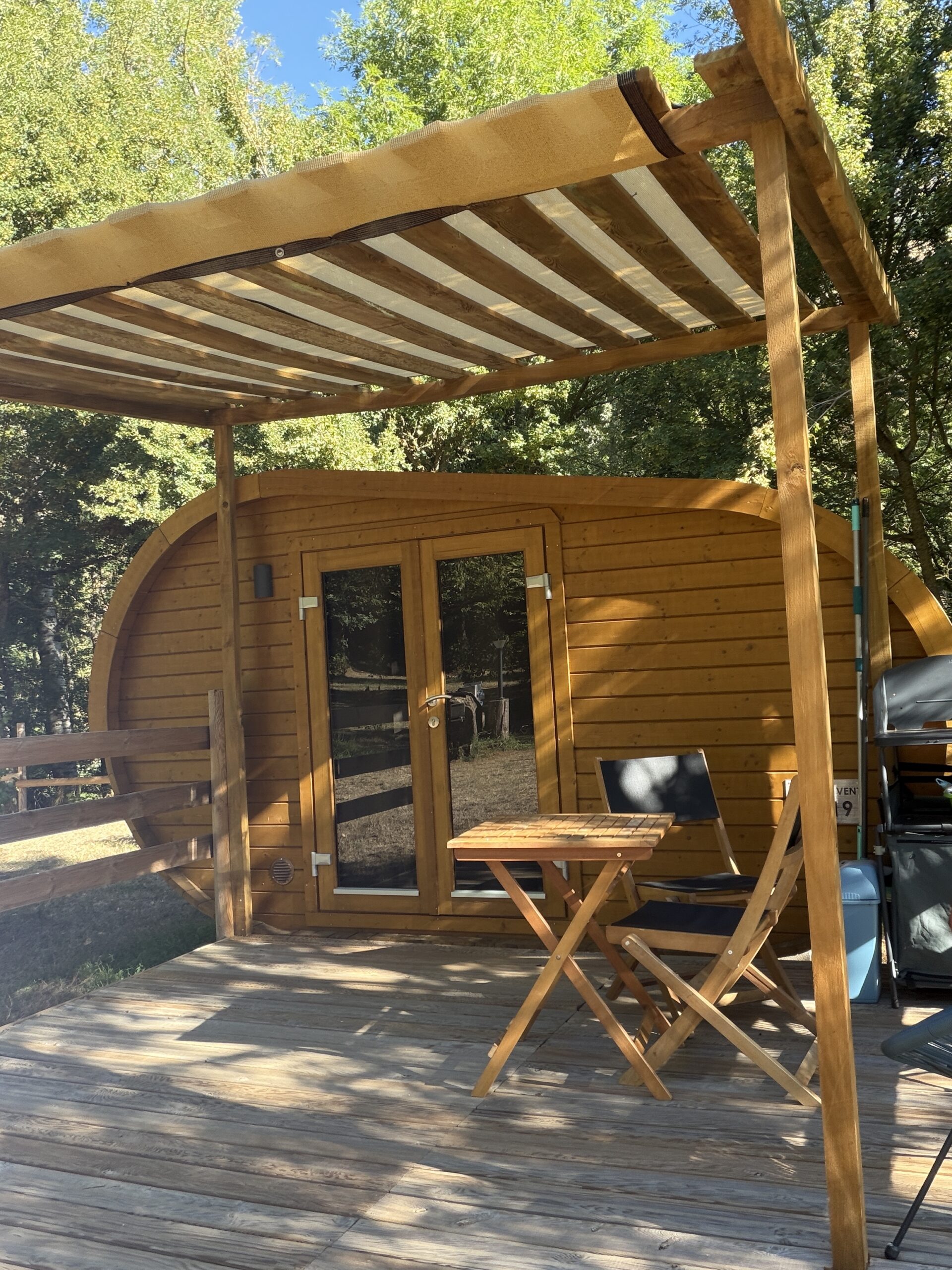 Terrasse en bois devant un chalet, entourée d’arbres
